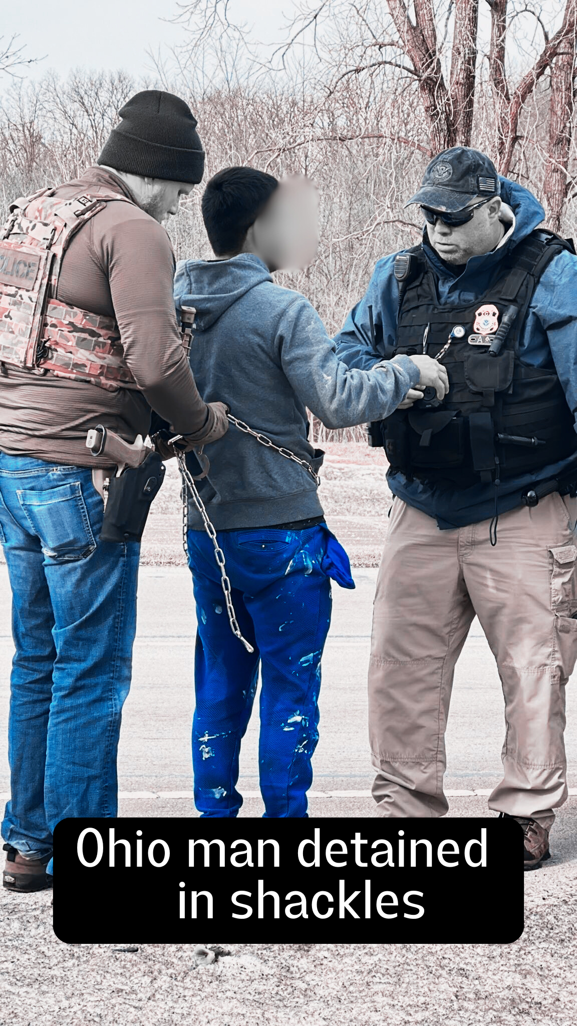 On the left, a man wearing jeans, a brown shirt, black hat, and camo vest tightens chain shackles placed on a man in ripped jeans and a gray hoodie. To his right, a heavy-set man in khakis and a black police vest with a hat appears to be speaking to him. The words say "Ohio man detained in shackles."