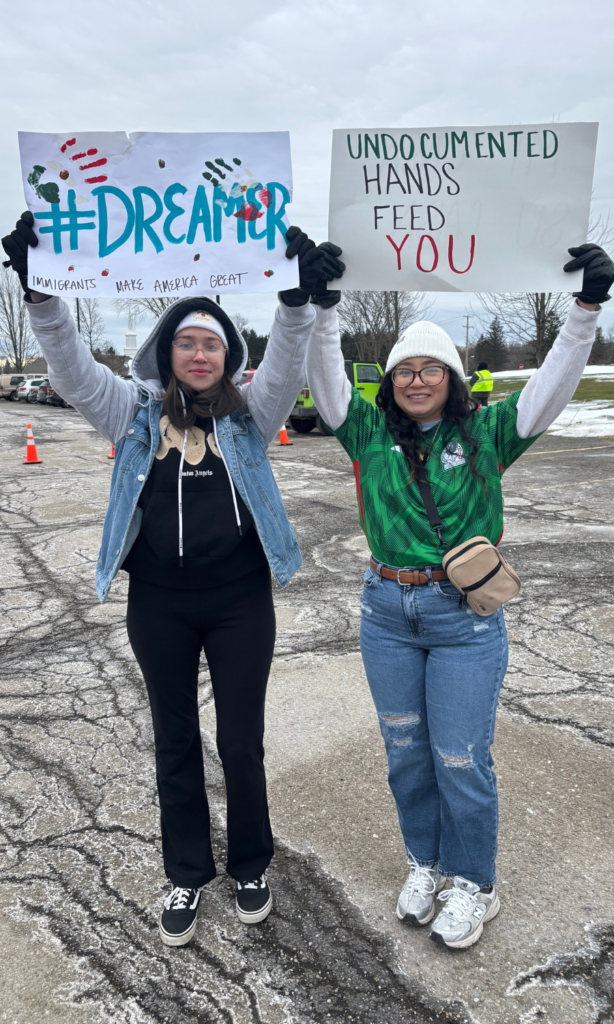 Two triumphant women hold signs